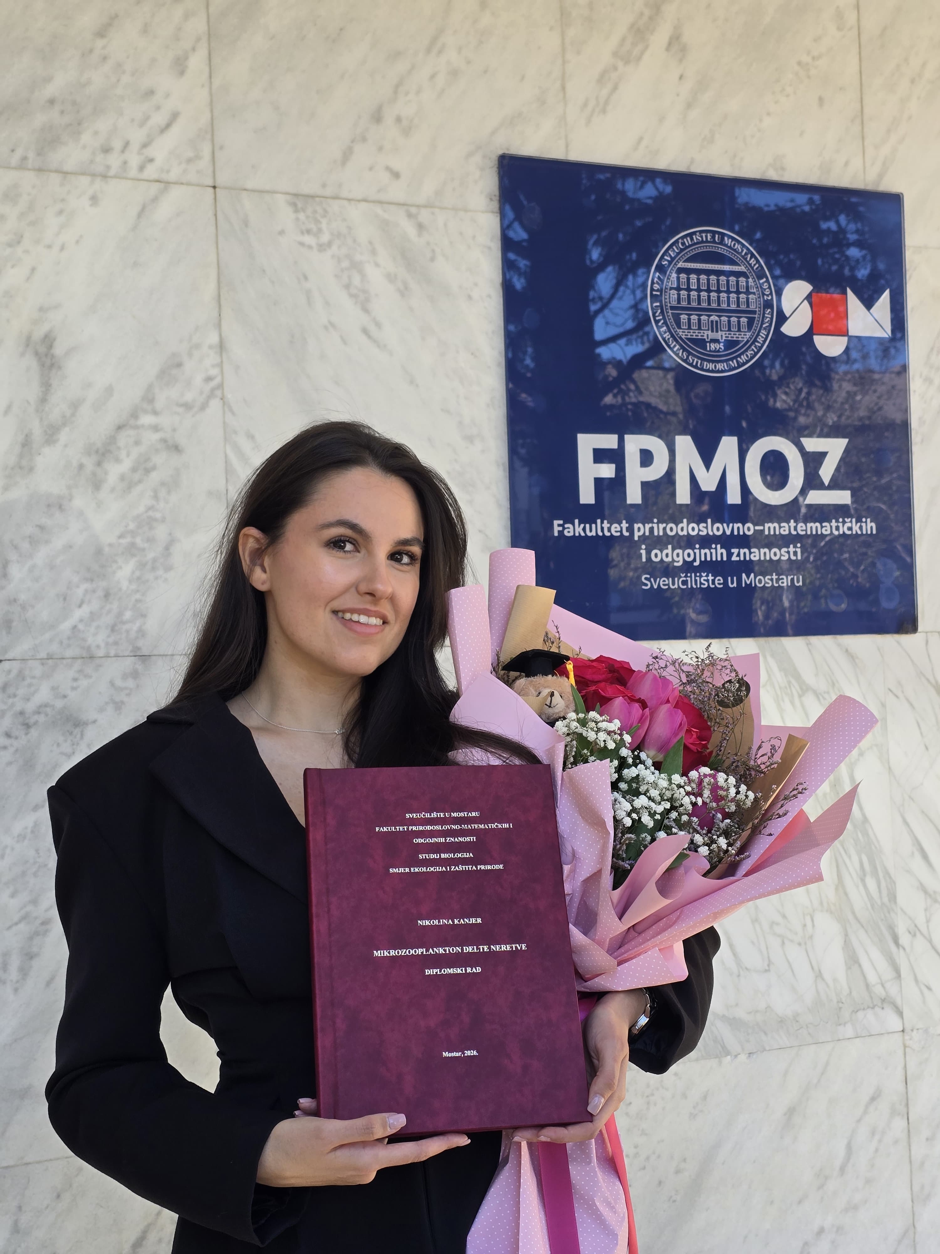Nikolina Kanjer with her master's thesis in front of the Faculty of Science and Education